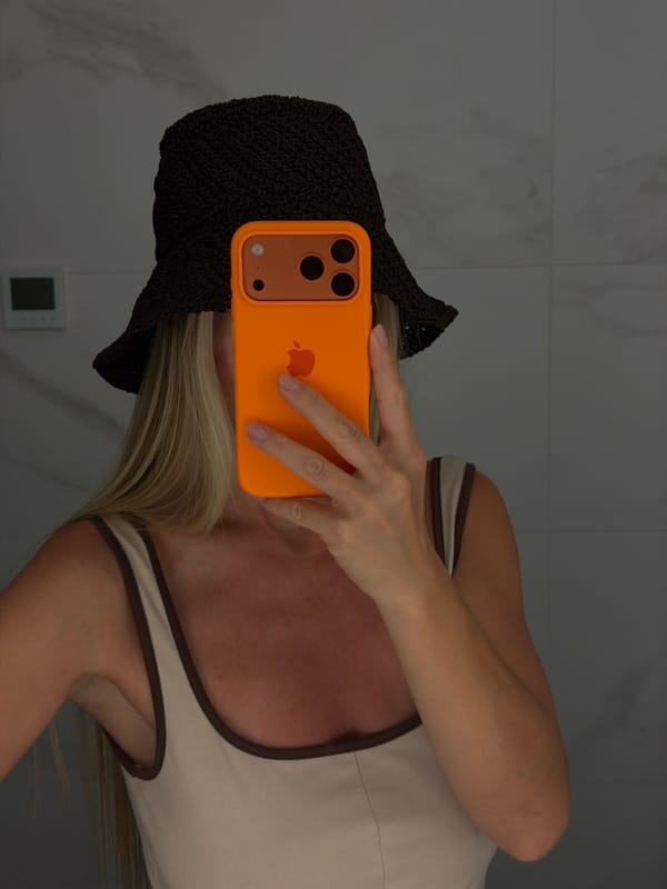 Mirror selfies in a Finestrat bathroom, orange iPhone in hand