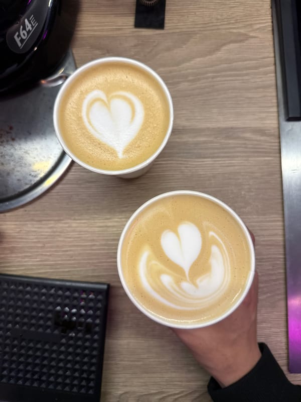 Two lattes with heart art on a wooden table in Moscow