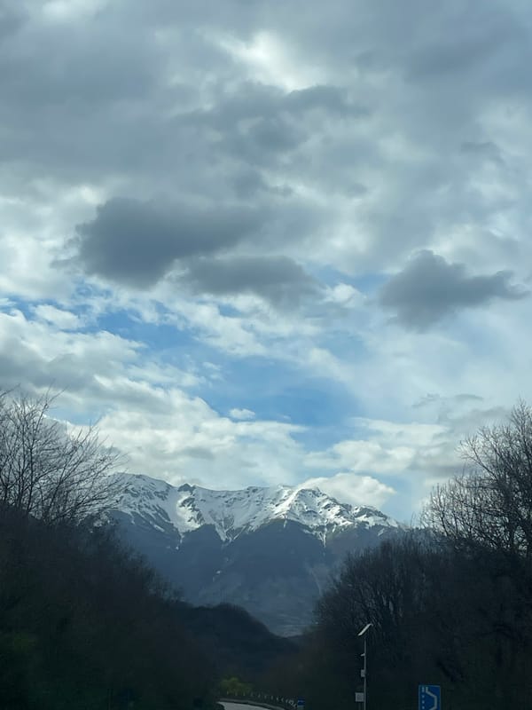 Snow-capped mountains photographed from vehicle in Italian countryside