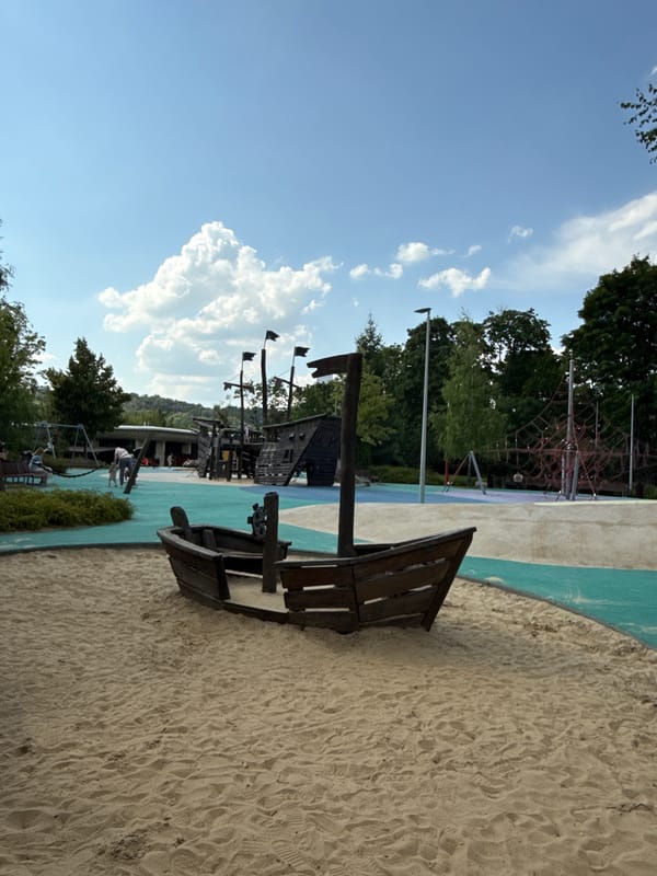 Riverside park scenes: playground, gardens, boat, and city views