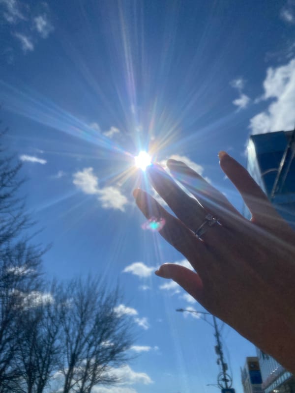 Hand reaches toward sun in Petropavlovsk-Kamchatsky evening sky