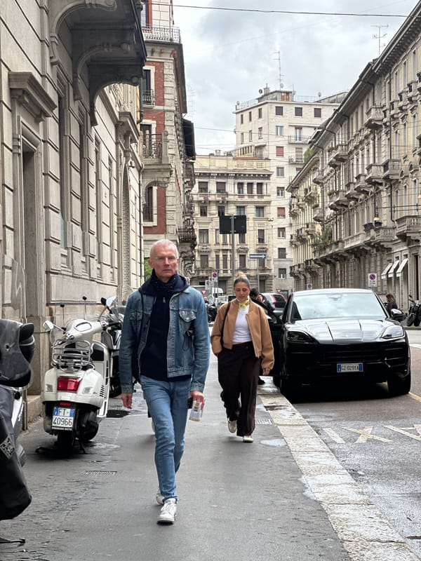 Two pedestrians walk Milan's narrow ornate streets