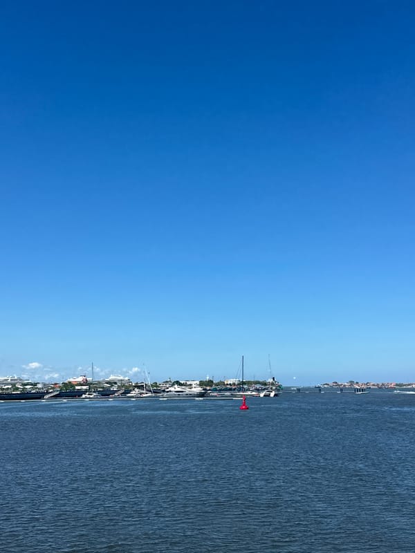 Motorcycle rider documents sunny waterfront journey through Denpasar-Kuta area