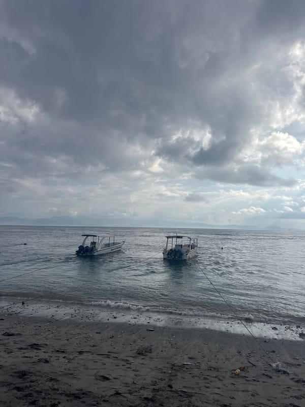 Dark sand, speedboats, and beach life on Nusa Penida