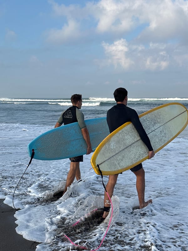 Surfers and beachgoers on a North Kuta morning