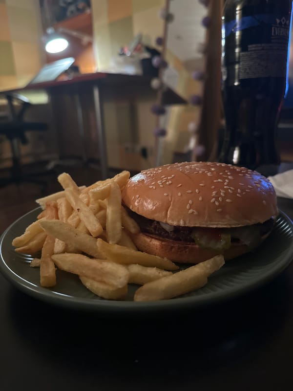 Person enjoys burger and fries while watching TV in Moscow
