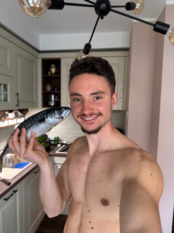 Man poses with mackerel fish in Sofia kitchen