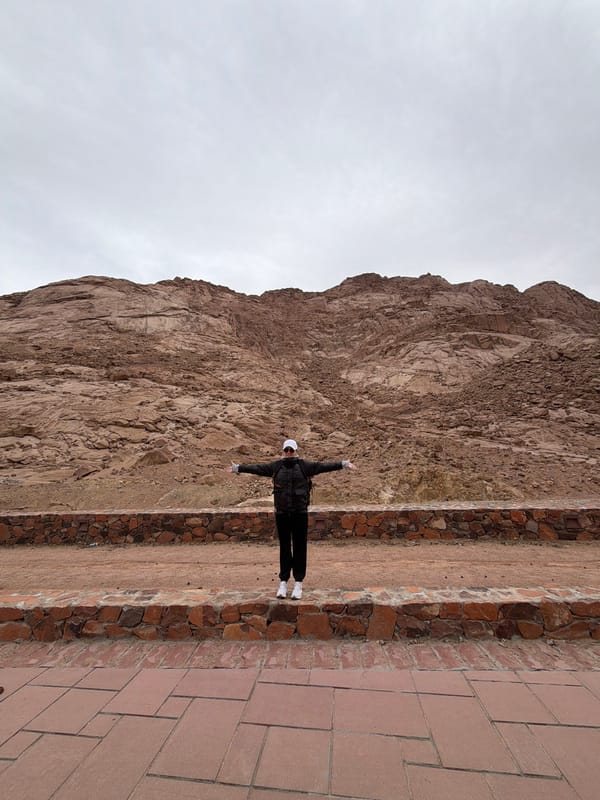Tourist poses with outstretched arms in Saint Catherine mountains
