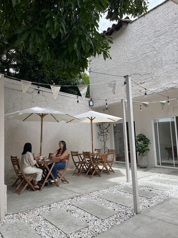 Women gather at outdoor patio table in Medellín