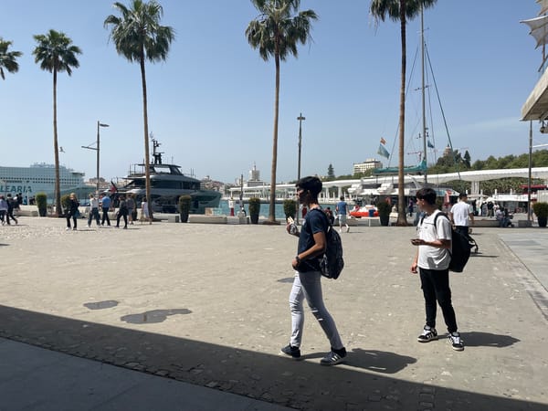 Two men walk through Málaga as arcade activity documented