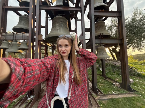Tourist photographs bell tower and scenic views in Montenegro village