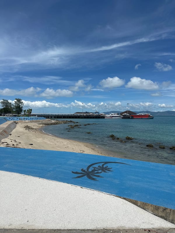 Naval ship docked at Koh Phangan pier, group activity nearby