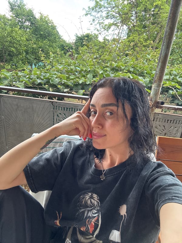 Woman takes selfies in garden setting in Kartubani, Georgia