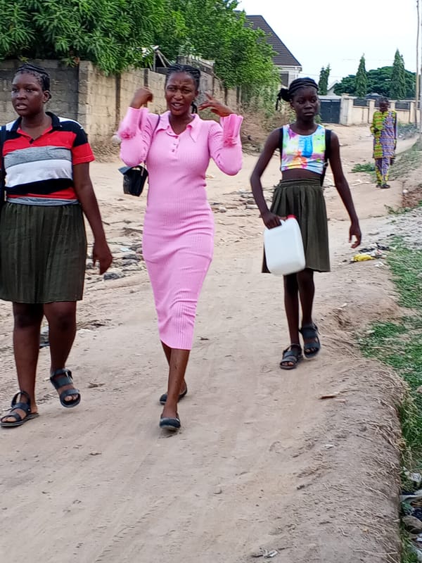 Pedestrians walk dirt road in residential area