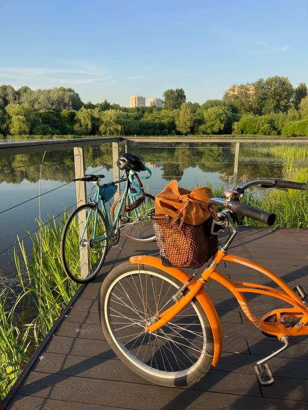 Cyclists gather at waterside boardwalk during golden hour