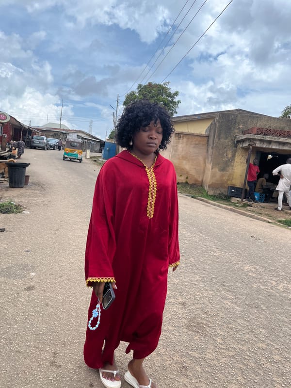 Midday street life in Jos: students, cars, and daily movement