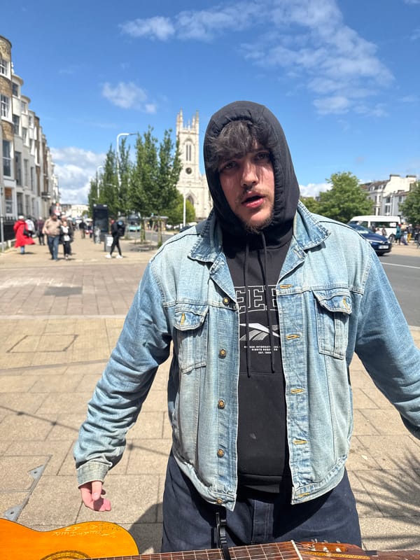 Man in denim jacket photographed on Brighton sidewalk