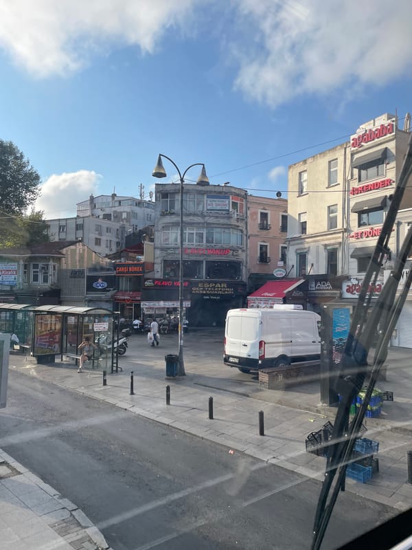 Kadıköy street scene: trams, buses, and shopfronts at dawn