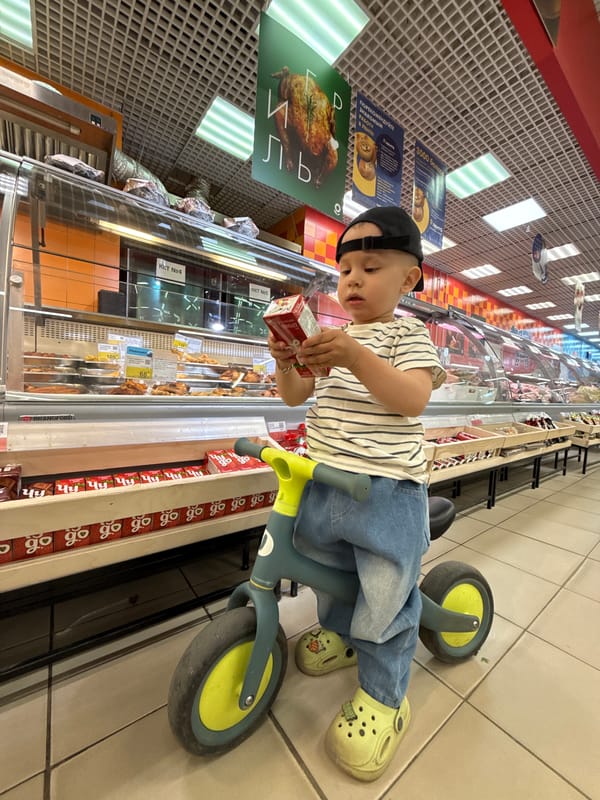 Family shopping trip with tricycle-riding child documented in Russia
