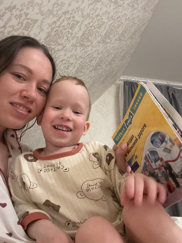 Mother and child share bedtime reading in Russian home