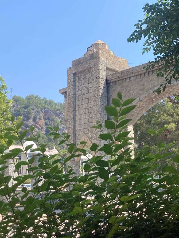 Stone archway and hanging decor in Kemer's green streets