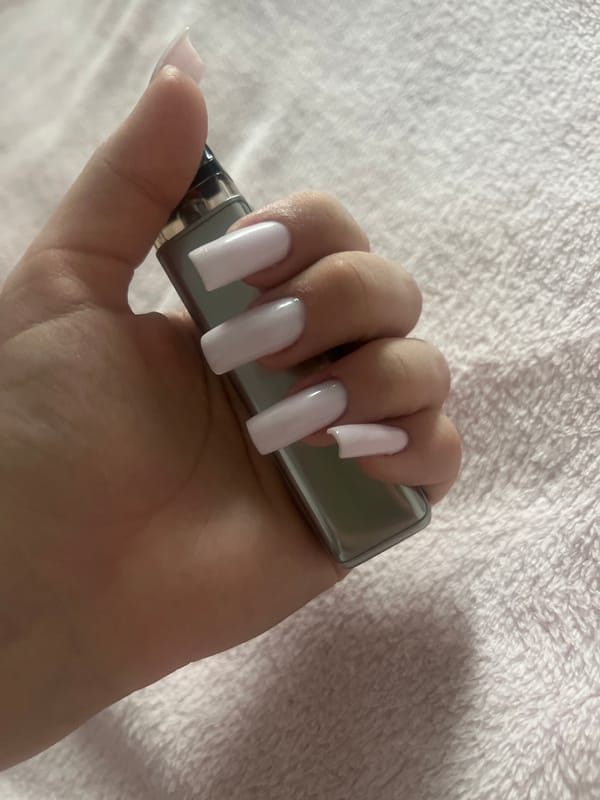 Person with decorated nails holds vape device in Russia