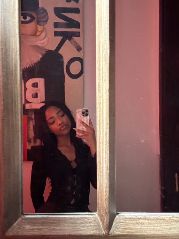 Woman Takes Mirror Selfie Near Cyrillic Poster in Moscow