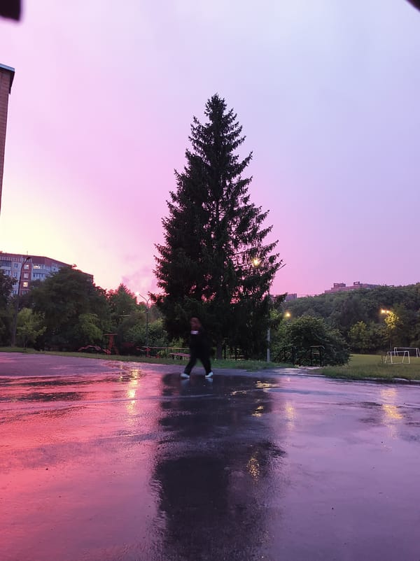 Rainy twilight across Ternopil streets and a local football field
