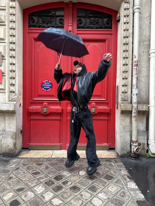 Woman jumps for photos at red Parisian door