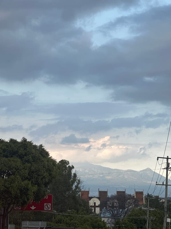 Overcast skies with breaking sunlight observed in urban area