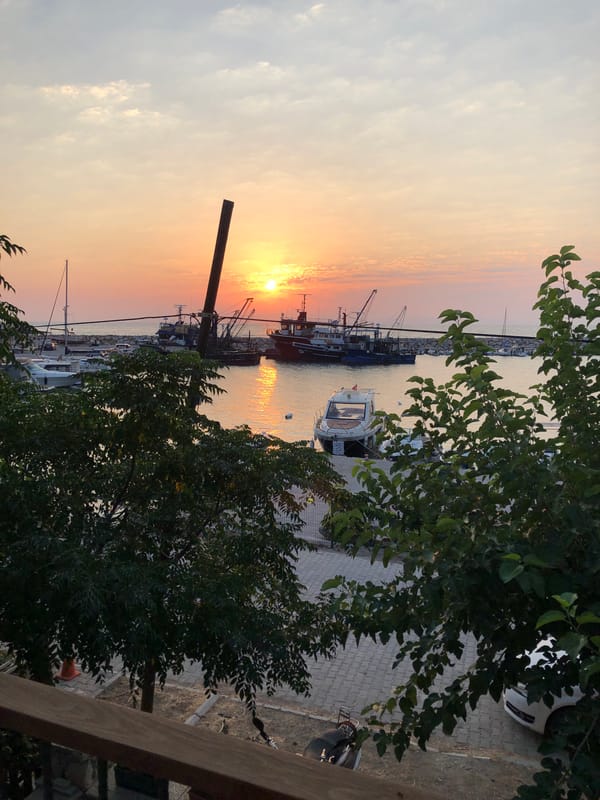 Sunset over Karaburun harbor, fishing boats at rest