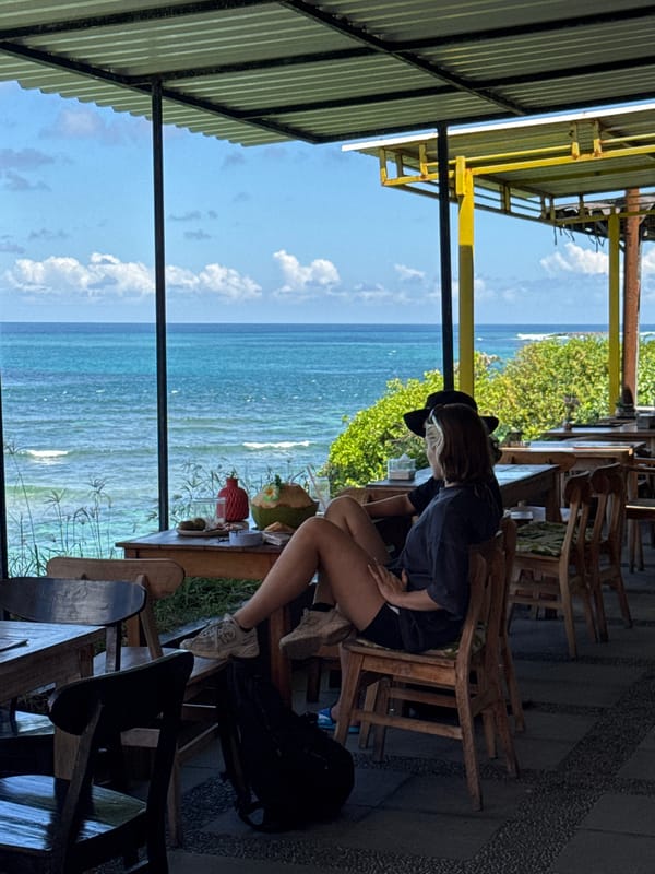 Woman takes selfies at oceanfront cafe in Kuta Selatan