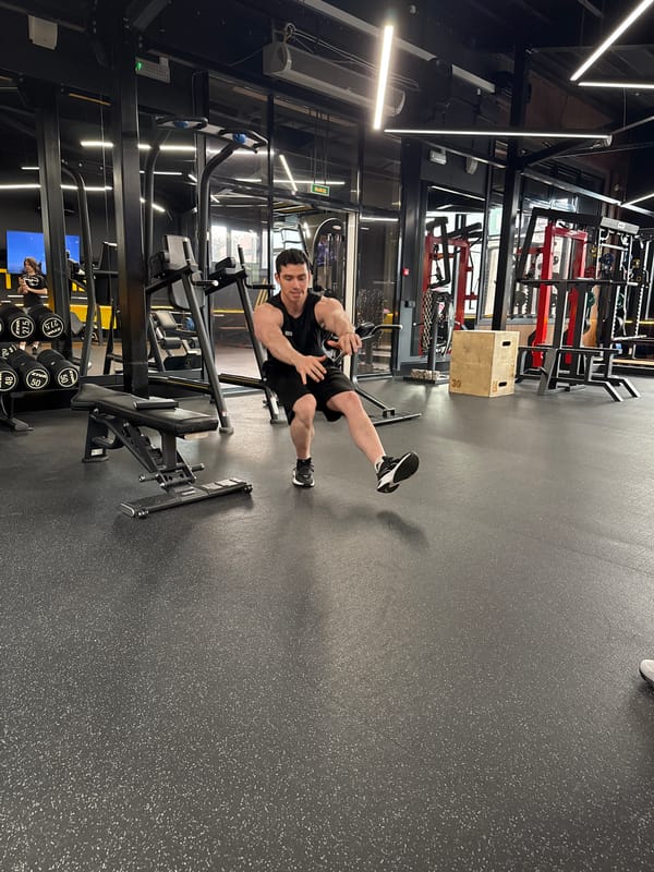 Men exercise with barbells at indoor gym facility