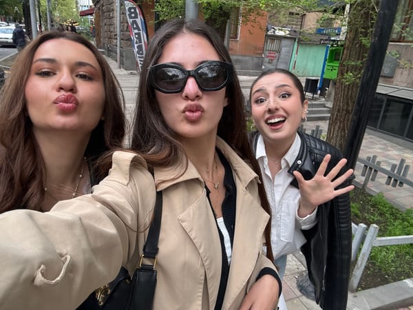 Three women take playful outdoor selfie