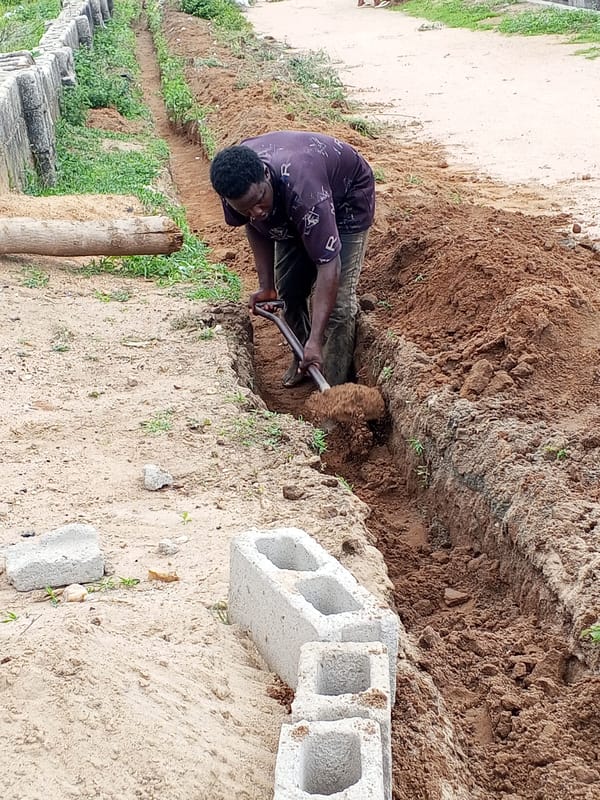 Workers dig trench alongside concrete blocks in Zango-ndaji, Nigeria