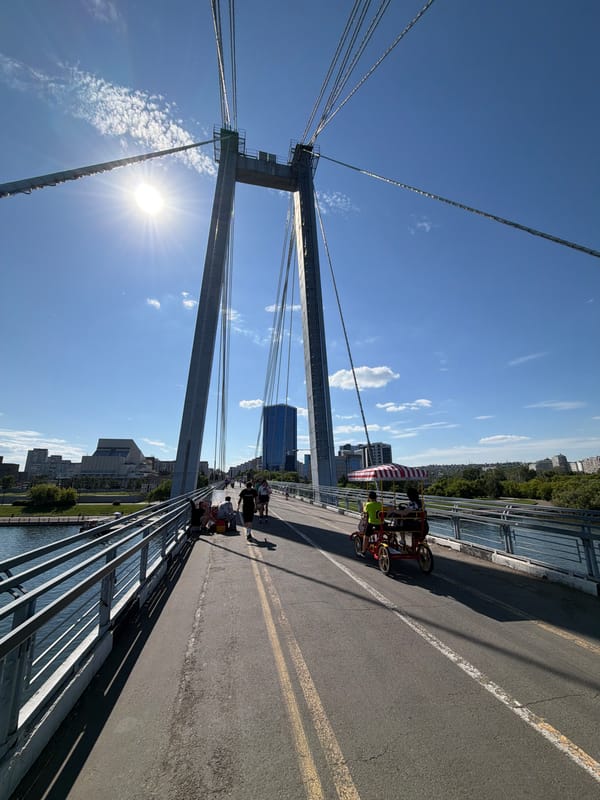 Summer morning along Krasnoyarsk's Yenisei riverfront and pedestrian bridge
