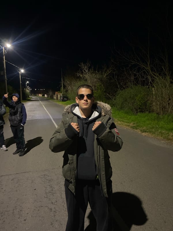 Teenagers gather on illuminated street in Goritsa, Bulgaria at night