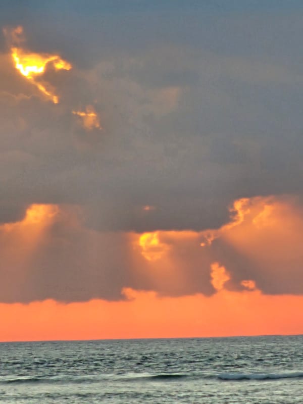 Dramatic sunset over a busy Denpasar beach