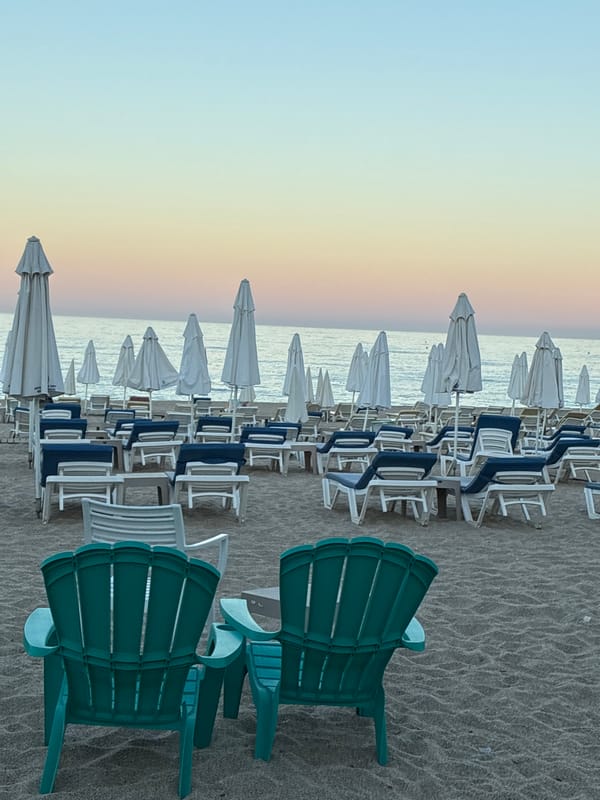 Alanya beach at golden hour, chairs, palms, and calm water
