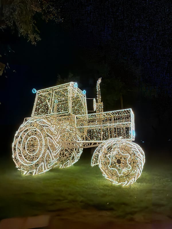 Illuminated tractor sculpture display documented in Minsk residential area