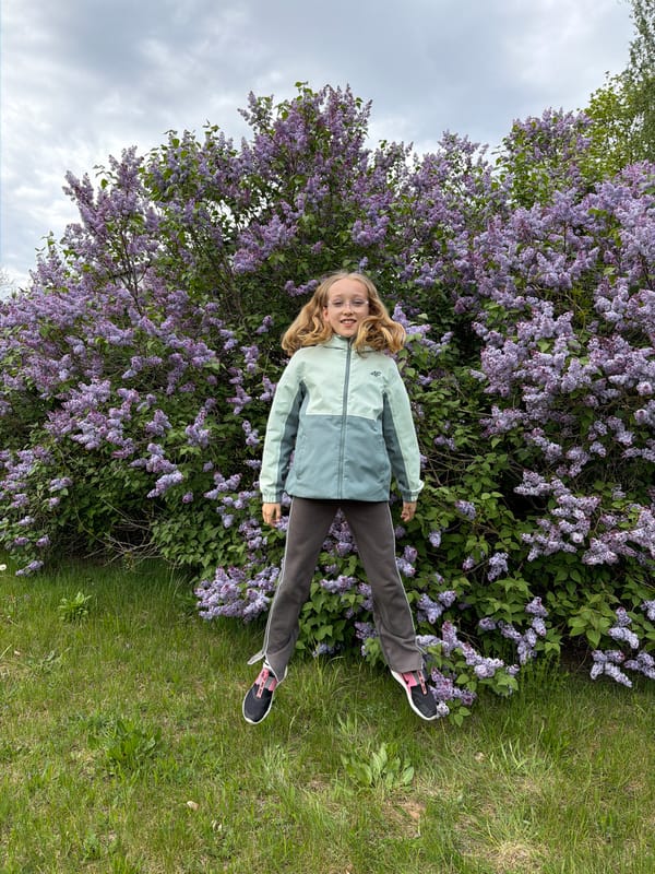 Spring afternoon captured in Dreiliņi: girl plays among blooming flowers