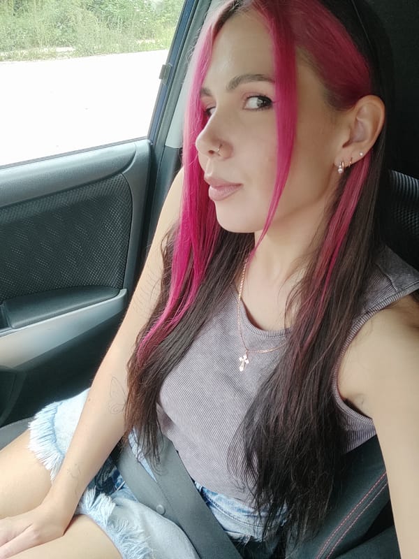 Passenger with pink-streaked hair in a vehicle near Noviy, Russia