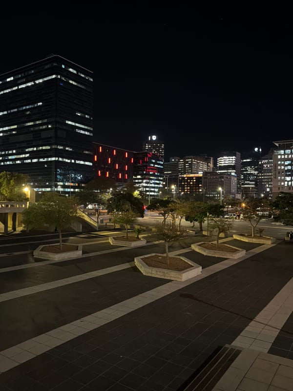 Person enjoys champagne against Cape Town city lights backdrop