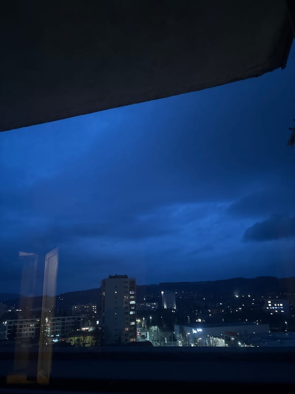Night view of illuminated Pernik cityscape from window