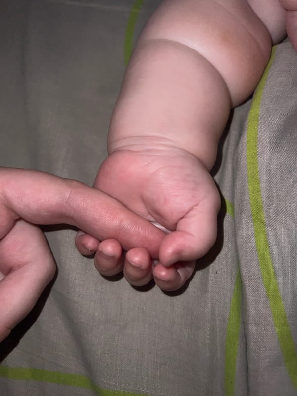 Tender adult-baby bonding moments captured in intimate indoor setting