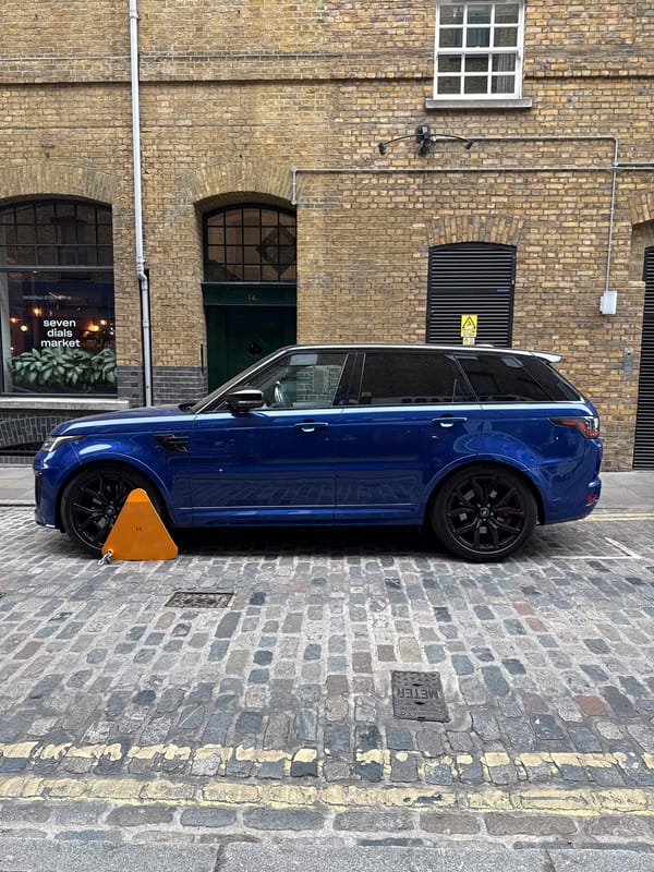 Blue Range Rover clamped on London cobblestone street