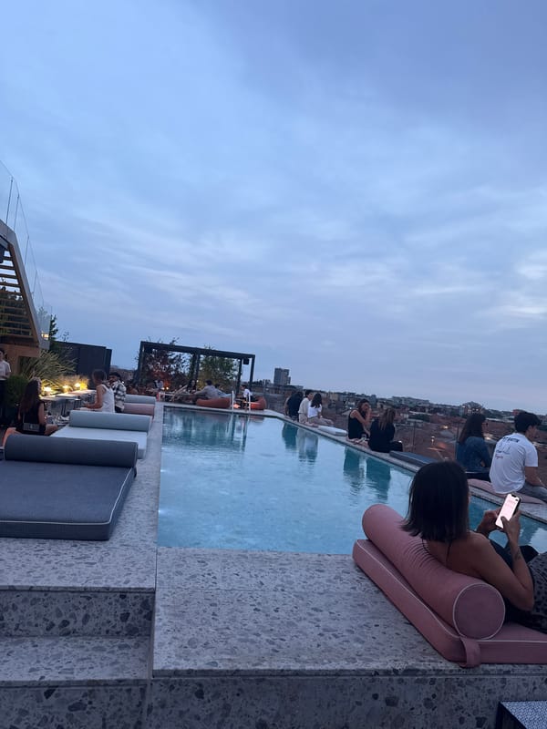 Evening rooftop pool party documented across Milan skyline