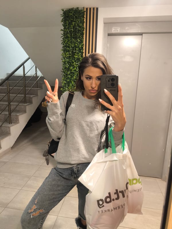 Woman with smartphone observed in apartment building hallway