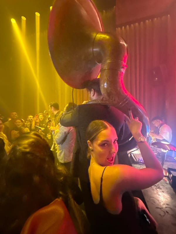 Woman poses with tuba in Madrid evening gathering