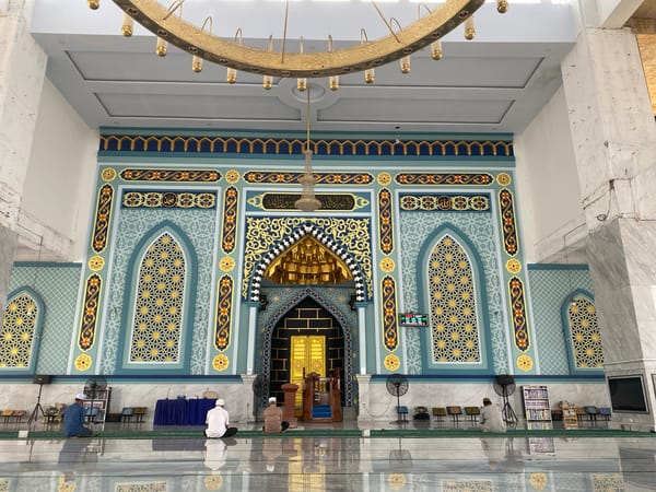 Prayer and ornate architecture inside Lhokseumawe's Islamic Center Mosque